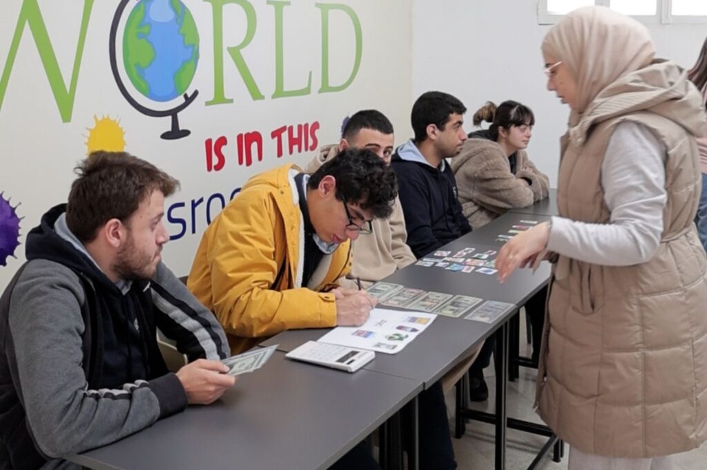 Group of people reviewing design materials and sketches at desk with globe artwork